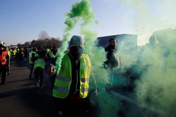 People wearing yellow vests, a symbol of French drivers' nationwide protest against higher fuel prices, block the Paris-Brussels motorway in Haulchin