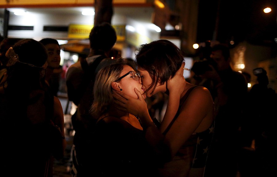 Лесбиянки в розовой одежде страстно целуются возле барной стойки