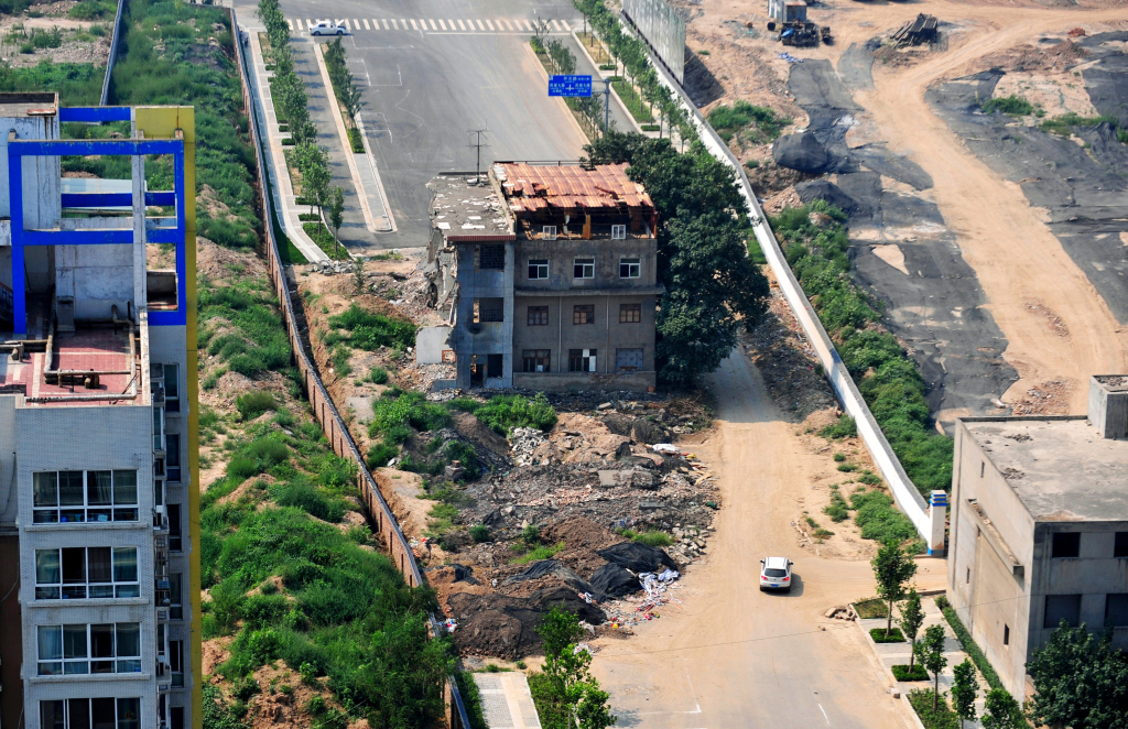 This house is currently diverting car traffic in Xi'an; the owners, a family of seven, refuse to move, opting instead to live without electricity or water.