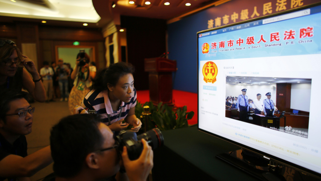 The prime source of news: the Jinan Courtroom's Sina Weibo page. A journalist takes pictures of a screen displaying a court's microblog page showing disgraced Chinese politician Bo Xilai standing trial inside the court, in Jinan, Shandong province August 22, 2013. Bo appeared in public for the first time in more than a year on Thursday to face trial in eastern China, the final chapter of the country's most politically charged case in more than three decades. REUTERS/Carlos Barria
