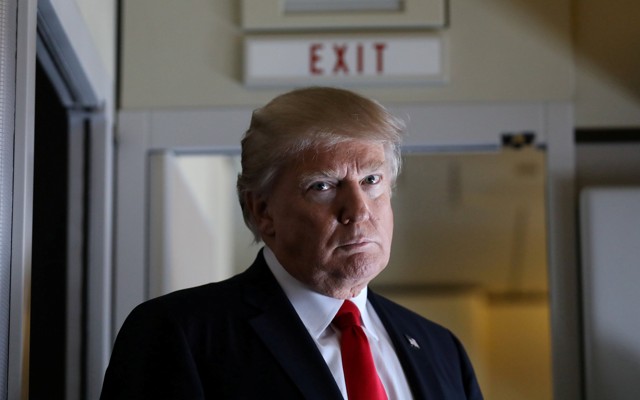 President Trump pauses as he talks to journalists.