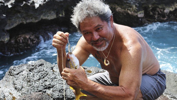 Umi Kai uses a traditional Hawaiian hook to catch a fish at the Papahanaumokuakea Marine National Monument in Hawaii in 2015.