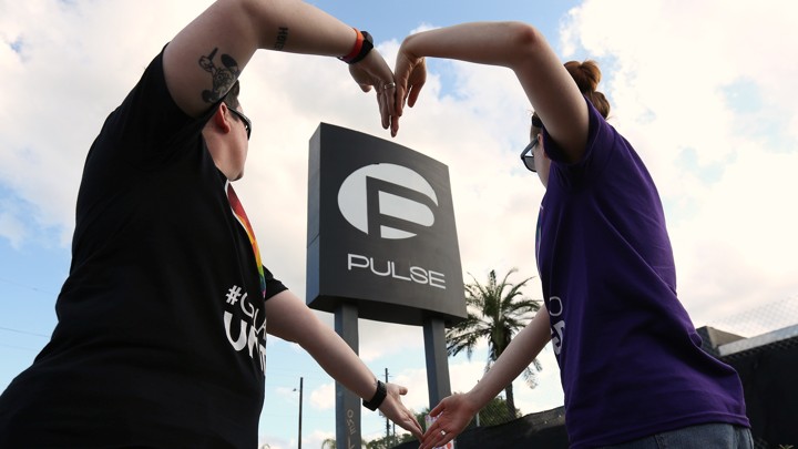Heather Raleigh and Paige Metelka make a heart shape as they pose during a photo shoot outside Pulse nightclub.