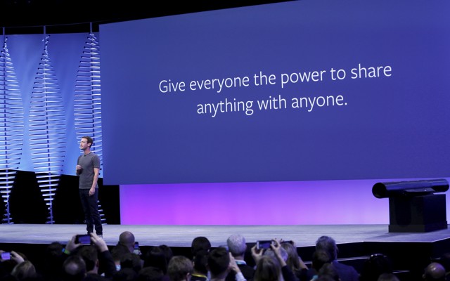 Mark Zuckerberg stands in front of a slide that says “Give everyone the power to share anything with anyone.”