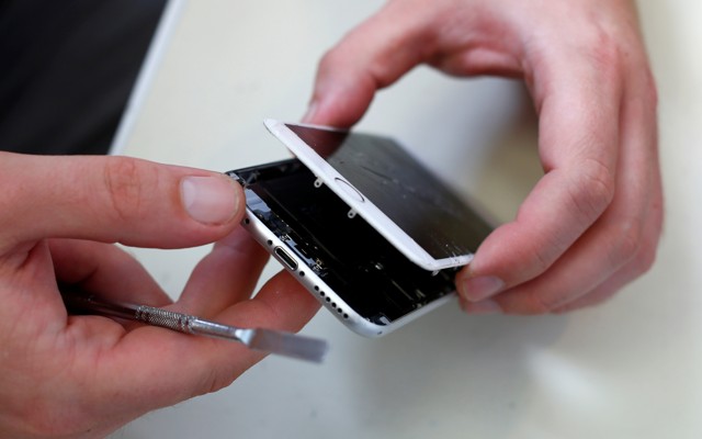 A technician repairing a broken iPhone