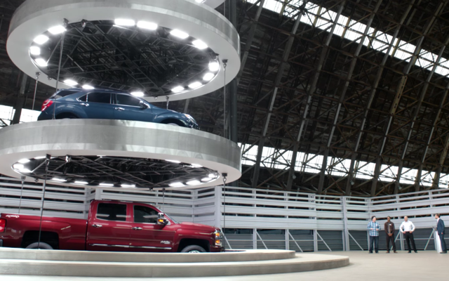 Cars on a large elevator as seen in a Chevrolet commercial