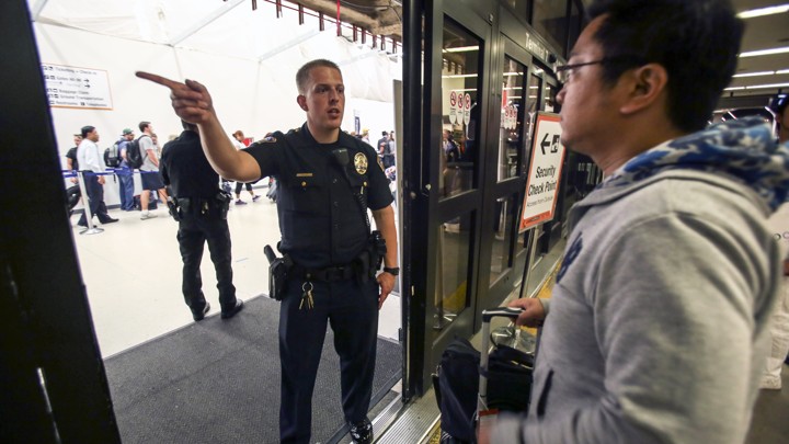 A police officer directs a passenger at Terminal 7 in Los Angeles International Airport, Sunday, Aug. 28, 2016.