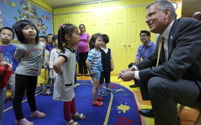 New York City Mayor Bill de Blasio smiles at children in a pre-k classroom in Brooklyn.