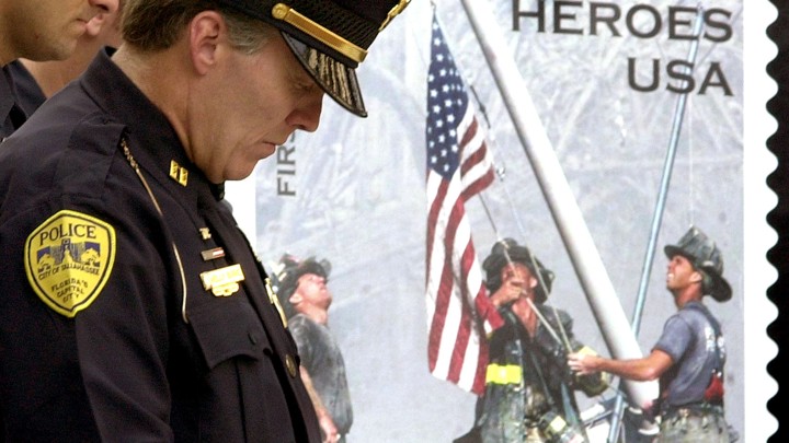 Tallahassee Police officer Kelly Burke bows his head to pray during a Sept. 11 rememberance ceremony at the Florida Capitol, Wednesday, Sept. 11, 2002.