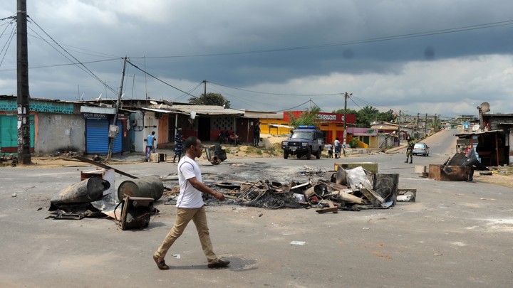 A man walks past remnants from election protests in Libreville, Gabon.