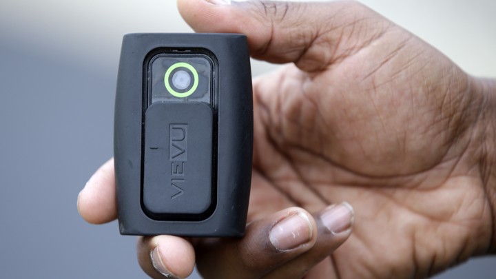 In this file photo taken on Tuesday, Sept. 29, 2015, Whitestown Police Department officer Reggie Thomas holds a body camera that he wears while on his shift, in Whitestown, Ind.