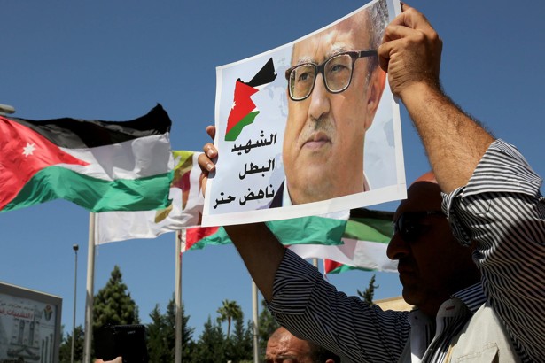 Protesters hold up photos of Jordanian writer Nahed Hattar outside the Jordanian Prime Ministry in Amman, Jordan. 