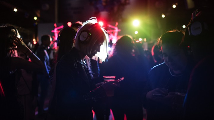 A woman looks at her phone as she takes part in a silent disco.