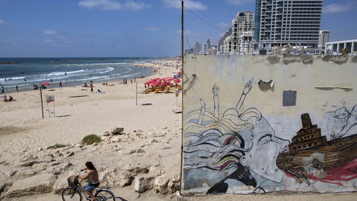 A boy rides a bike on Tel Aviv's beach front.