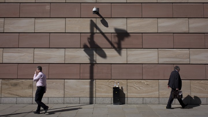 Two men pass in front of a surveillance camera