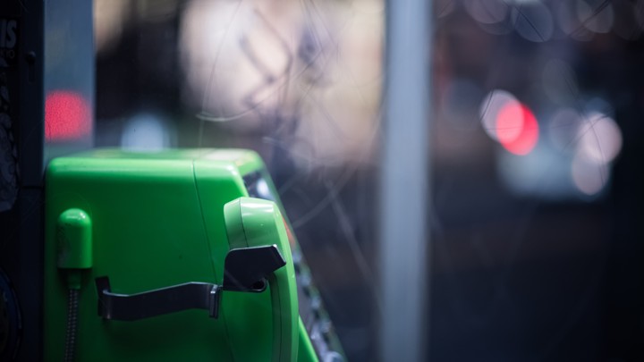 A green telephone in a phone booth