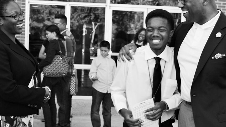 Paul Quinn College president Michael Sorrell embraces a smiling person.