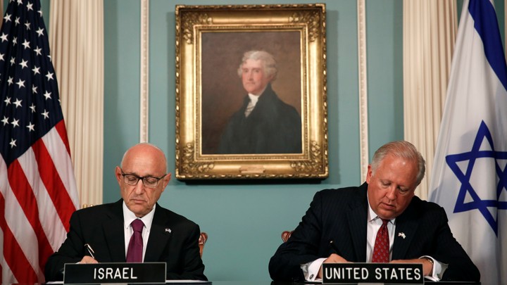 U.S. and Israeli officials sign an unprecedented military-spending deal in Washington, D.C. on September 14, surrounded by a portrait of Thomas Jefferson and American and Israeli flags.