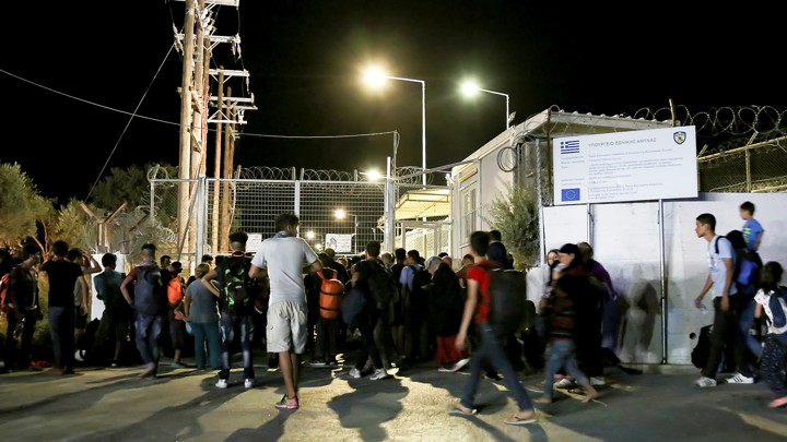 Migrants gather outside a Lesbos refugee camp after a fire forced them to flee