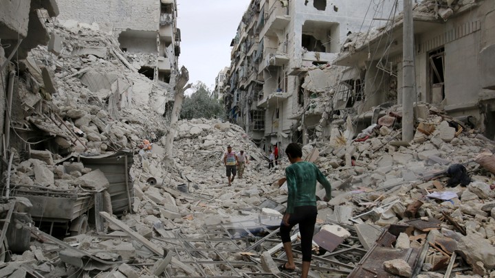 People inspect the damage left after an airstrike hit the rebel-held neighborhood of Tariq al-Bab Friday in Aleppo, Syria.
