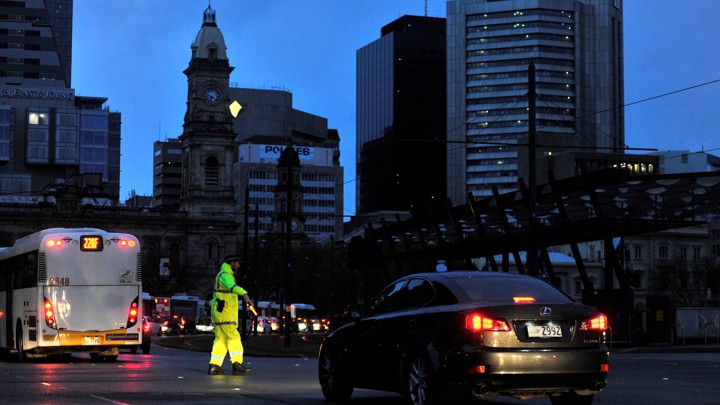A traffic policeman directs vehicles in the blackout in Adelaide, Australia, on Wednesday.