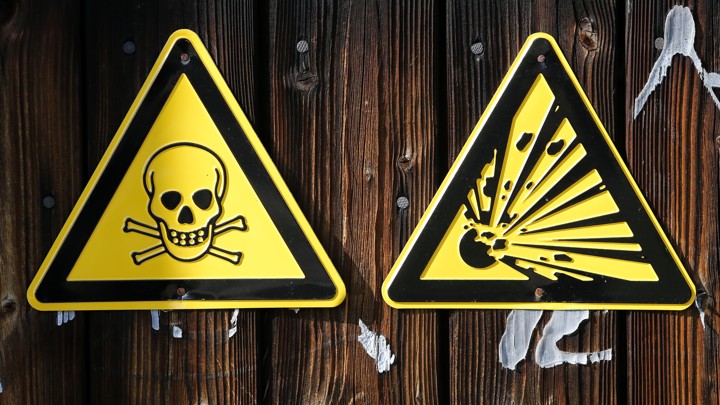 Warning signs hang on a wall at chemical weapons destruction site at the Society for the Disposal of Chemical Weapons and Ordnance .