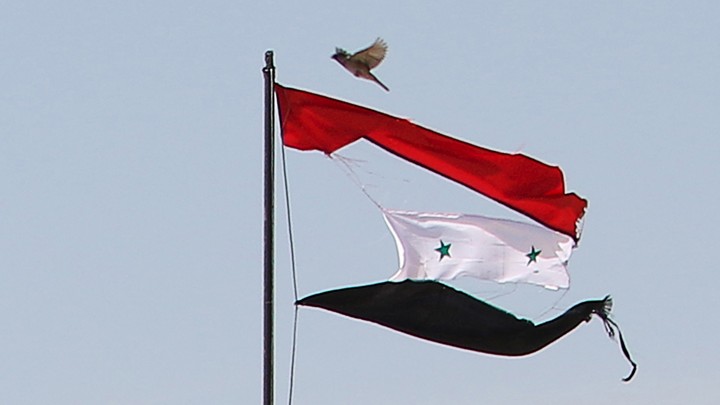 A tattered Syrian flag waves in the northeastern city of Qamishli, Syria.