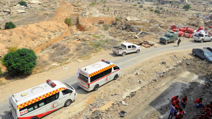 A Syrian Arab Red Crescent convoy waits at the entrance of the besieged Damascus suburb of Daraya on August 26, 2016.