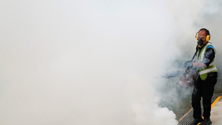 A worker uses insecticide to fog the common area of a public housing estate in Singapore, in an area where 189 cases of locally-transmitted Zika have been reported.