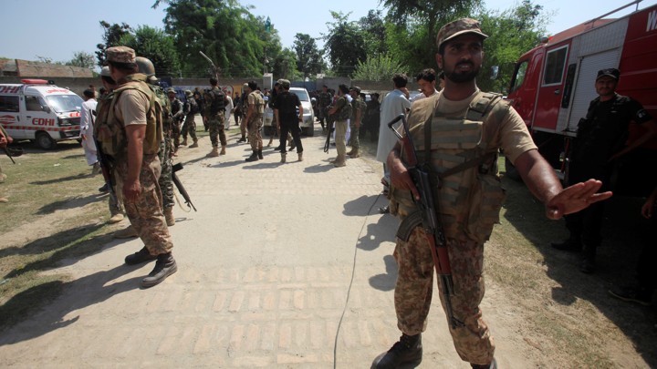 An Army soldier, stops member of the media as he guards the area with others, after suicide bombers attacked a courthouse.