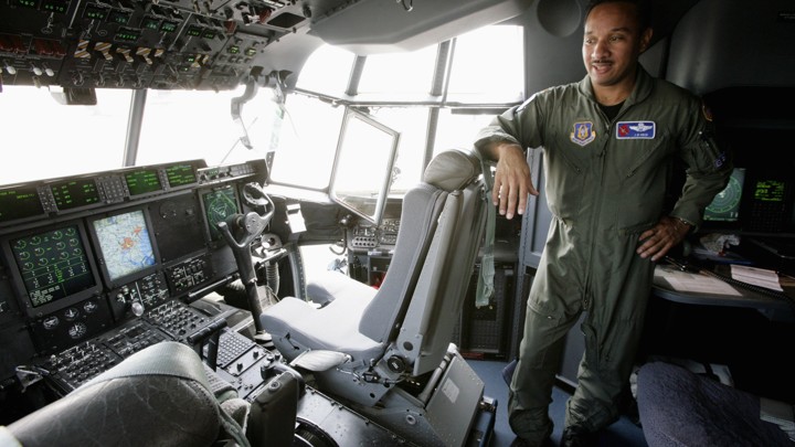 JD Haig, an Air Force Reserve pilot, stands in the cockpit of the Hurricane Hunter WC-130J, in 2007.