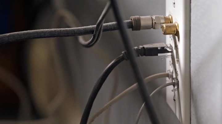 Internet and TV cables plugged into a wall