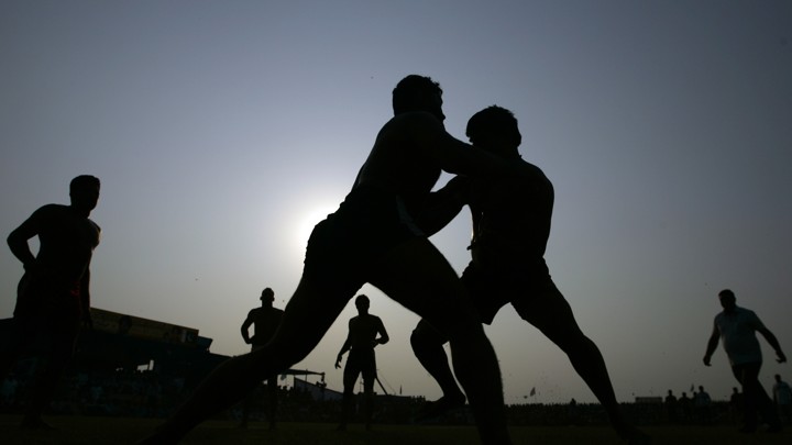 A silhouetted picture of Indian and Pakistani players as they compete in a Kabbadi match.