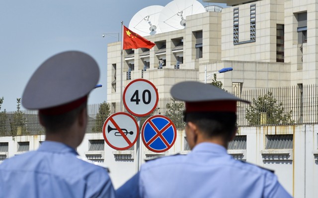 Kyrgyz police officers look at the Chinese Embassy after a suicide bombing in Bishkek, Kyrgyzstan.