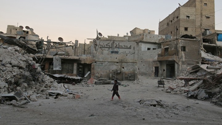 A boy walks amid damaged buildings in the rebel held area of al-Kalaseh neighbourhood of Aleppo.