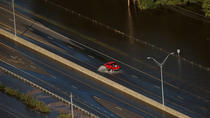 A car drives through flood waters along Interstate 95 after Hurricane Matthew hit Lumberton, North Carolina.