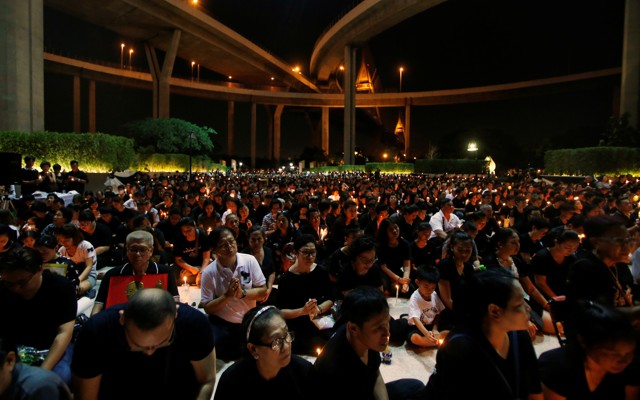 People pay their respect to the late King Bhumibol Adulyadej during a candlelight vigil at Lat Pho Park in Song Khanong, Thailand October 19, 2016. 