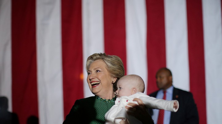 Hillary Clinton holds a baby after attending a campaign rally in Charlotte, North Carolina on October 23, 2016.