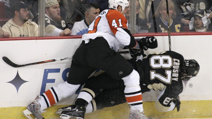Sidney Crosby gets checked into the boards