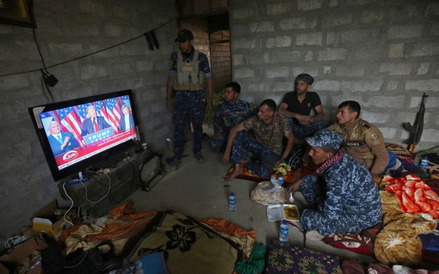 Members of the Iraqi forces watch Donald Trump giving a speech after he won the U.S. president election.