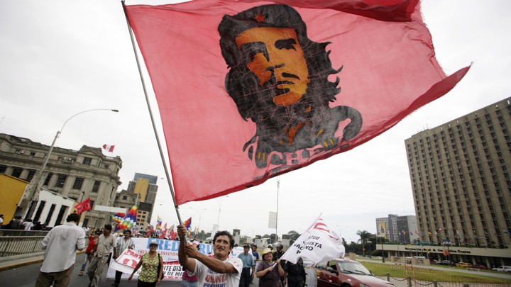 A man carries a flag with the image of Che Guevara during a march against Peruvian President Alan Garcia in downtown Lima April 13, 2010.