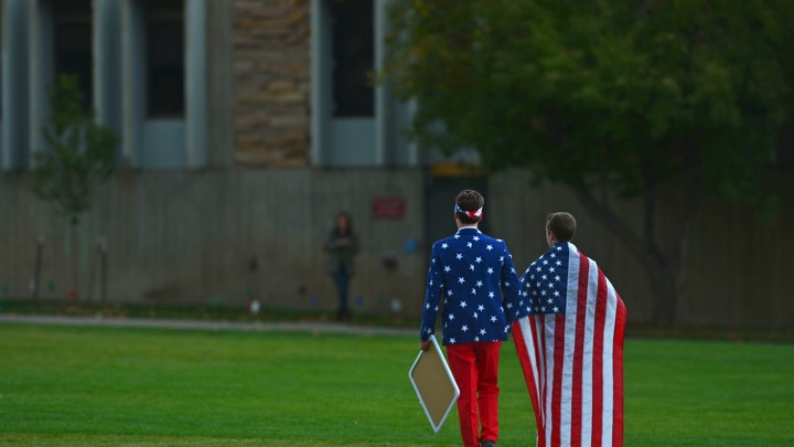 Two boys' backs face the camera. They are wearing American-flag apparel.