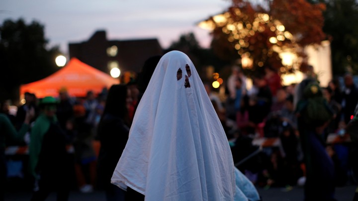 A man in a ghost costume marches in the annual Nyack Halloween Parade, in October 2016.
