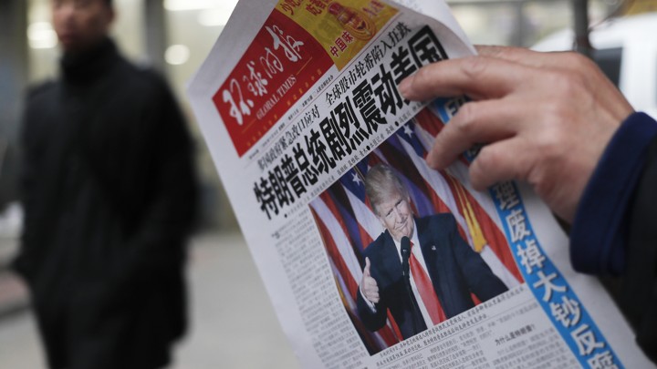 A man reads a newspaper with the headline of "U.S. President-elect Donald Trump delivers a mighty shock to America" at a news stand in Beijing.