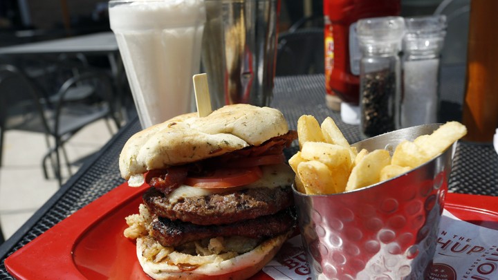 A hamburger with french fries and a milkshake
