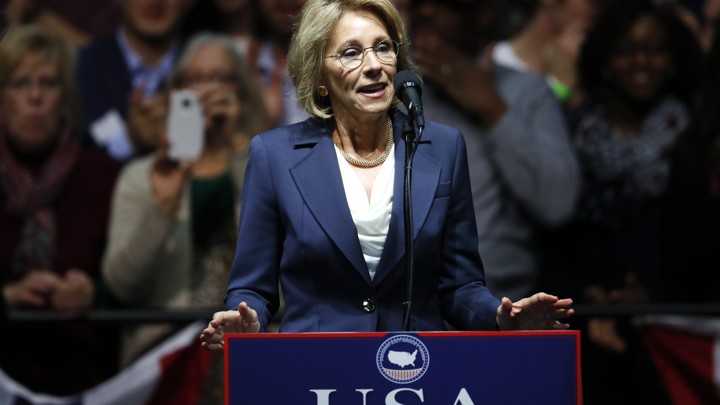 Betsy DeVos stands at a podium.