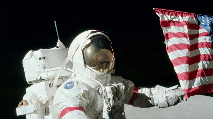 Gene Cernan holds the American flag during a spacewalk on the Apollo 17 mission on December 12, 1972.