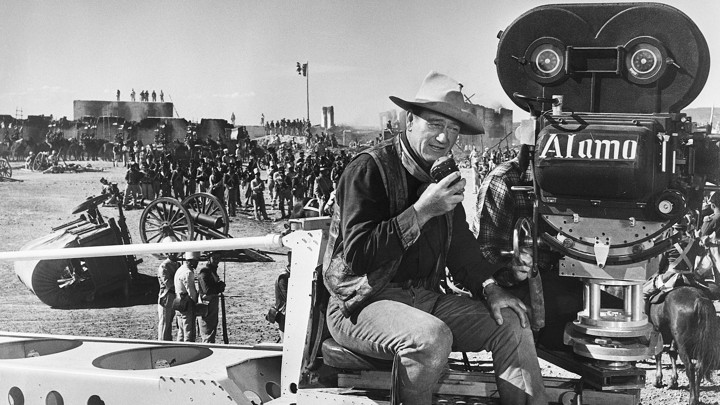 John Wayne dressed as a cowboy directs the filming of "The Alamo" in 1960.