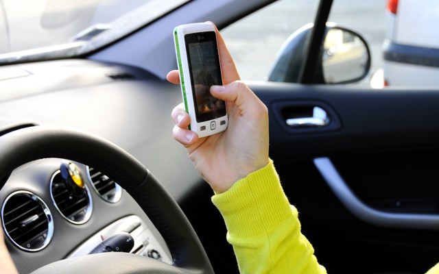 A driver uses a smartphone app in a car