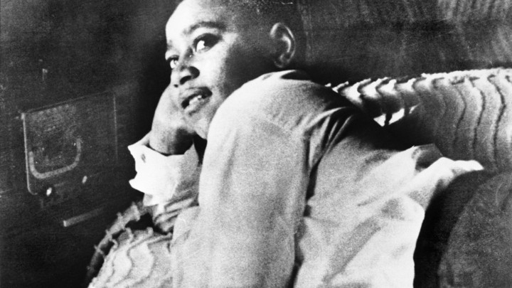 Emmett Till is shown lying on his bed.